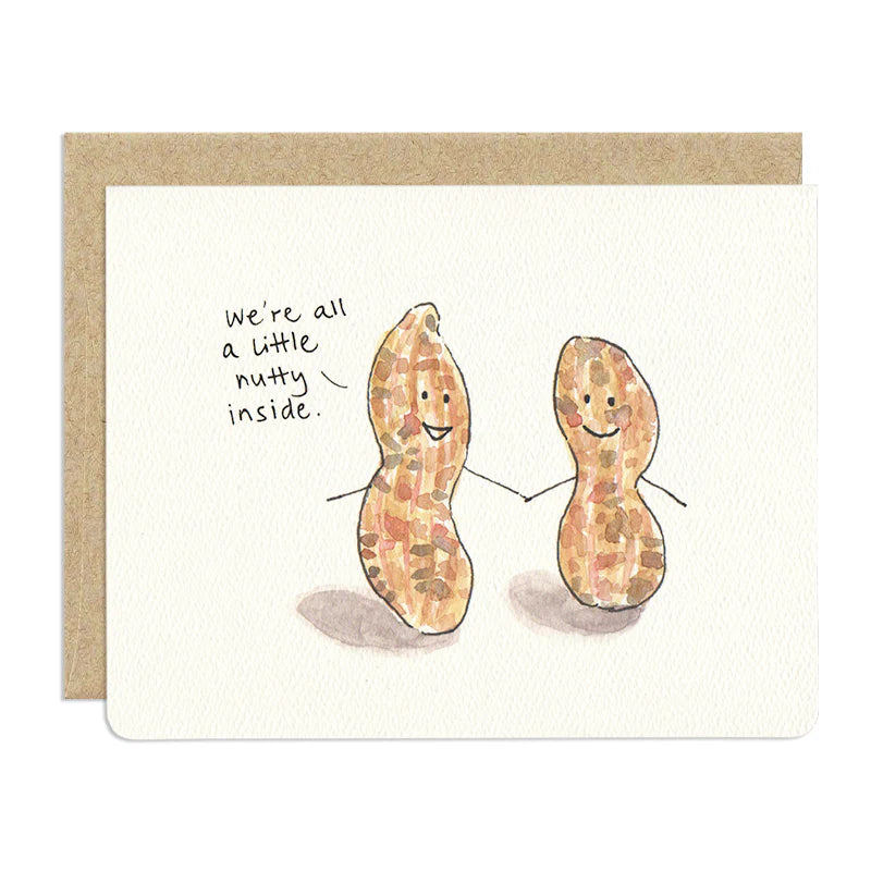 The image is a greeting card featuring a humorous illustration of two peanuts. The background is a textured, off-white paper, and a Kraft brown envelope border is visible on the left side, suggesting the card is partially opened or presented within it.
The peanuts are depicted standing side-by-side and holding hands, with thin black lines for their arms. Both peanuts have smiling faces with two dots for eyes and a curved line for a mouth.
To the left, The text reads: "we're all a little nutty inside".