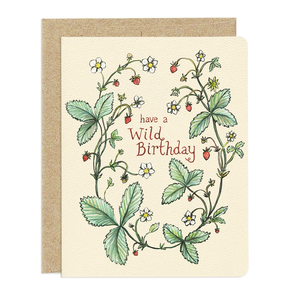 The card itself is a light, creamy yellow color with rounded corners.
The design of the card is an illustration of wild strawberry plants. The plants form an organic u-shaped arrangement, framing the text "have a wild birthday".
The leaves are depicted in various shades of green, with detailed serrated edges and visible veins. Small, delicate white flowers with yellow centers are scattered throughout the foliage, along with tiny red strawberries, some ripe and others still developing.