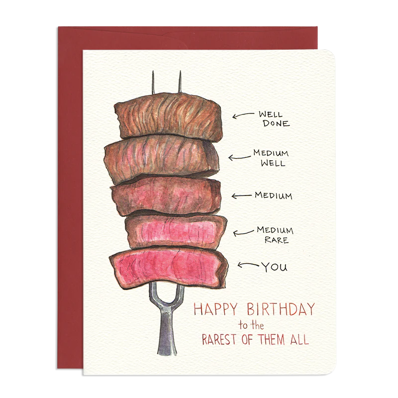 The image is a birthday card with a humorous illustration of steaks cooked to different doneness levels. The card has a cream-colored background and is framed by a dark red border.

The central element is a stack of five thick, rectangular steak slices impaled on a silver meat fork. The steaks are arranged vertically, with the top slice appearing the most cooked and the bottom slice the least cooked.
Below the steak illustration, there is handwritten text in a reddish-brown color. The text reads "HAPPY BIRT