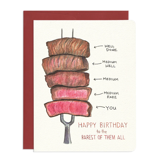 The image is a birthday card with a humorous illustration of steaks cooked to different doneness levels. The card has a cream-colored background and is framed by a dark red border.

The central element is a stack of five thick, rectangular steak slices impaled on a silver meat fork. The steaks are arranged vertically, with the top slice appearing the most cooked and the bottom slice the least cooked.
Below the steak illustration, there is handwritten text in a reddish-brown color. The text reads "HAPPY BIRT